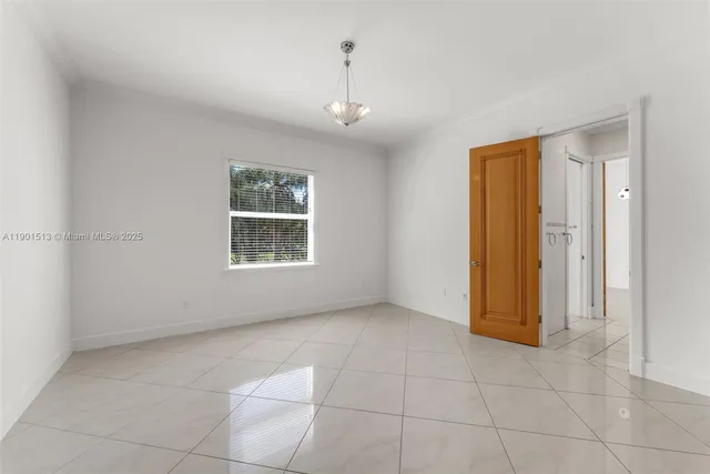 a front view of a house with a yard and potted plants
