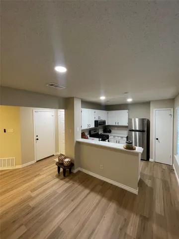 a kitchen with a refrigerator and a stove top oven