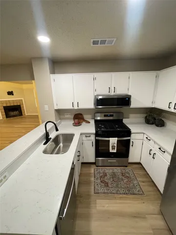 a kitchen with a sink a stove and cabinets
