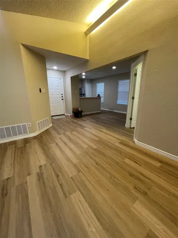 a view of empty room with wooden floor