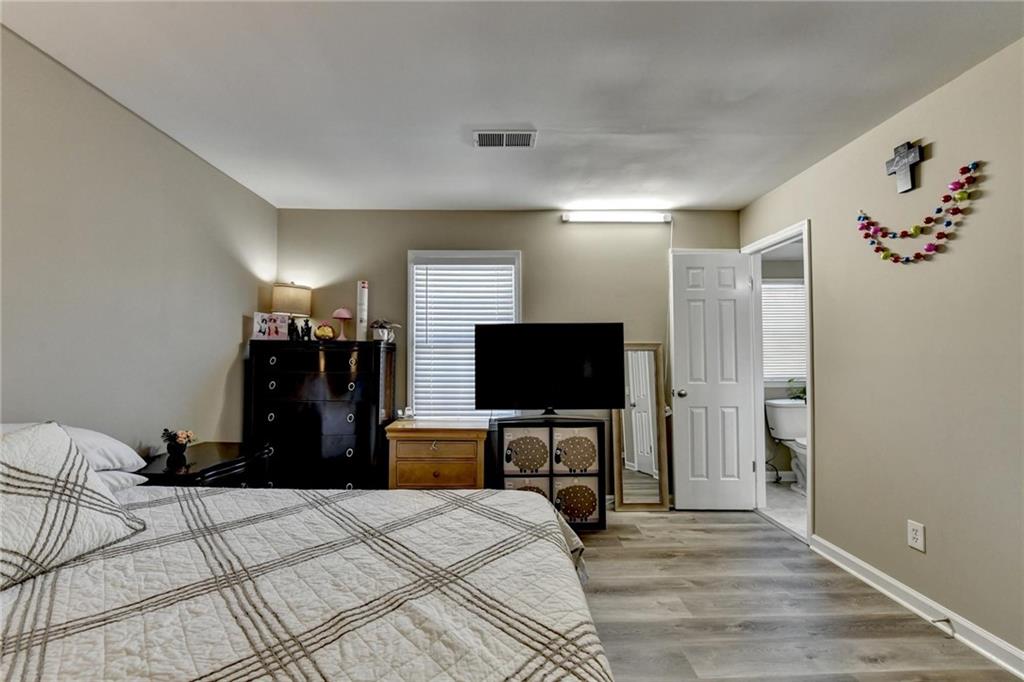 992 Old Holcomb Bridge Road Roswell, GA 30076 - Photo 23 of 34 a bedroom with a bed and a flat tv screen on wall