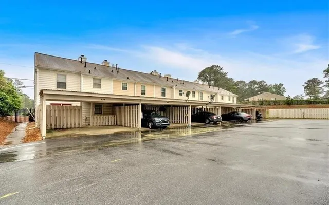 a view of a big house with wooden fence