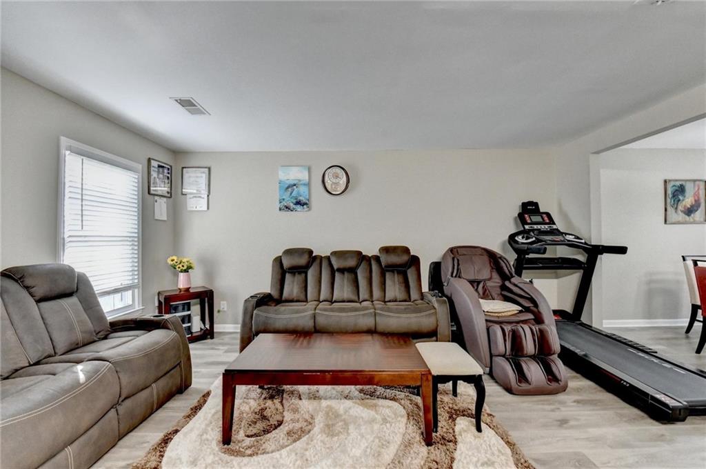992 Old Holcomb Bridge Road Roswell, GA 30076 - Photo 7 of 34 a living room with furniture a rug and gym equipment
