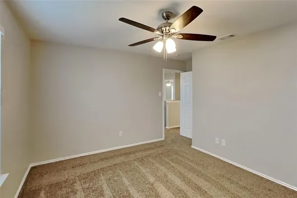 an empty room with a fan and a fan