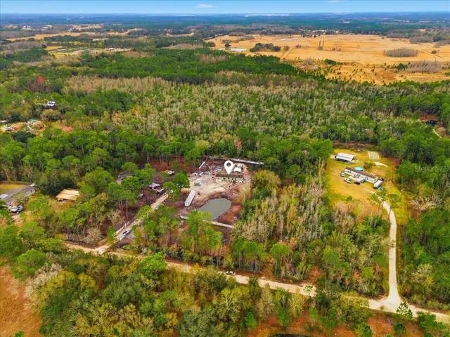 an aerial view of residential houses with outdoor space and trees