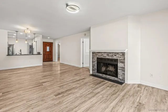 a view of a livingroom with wooden floor and a fireplace