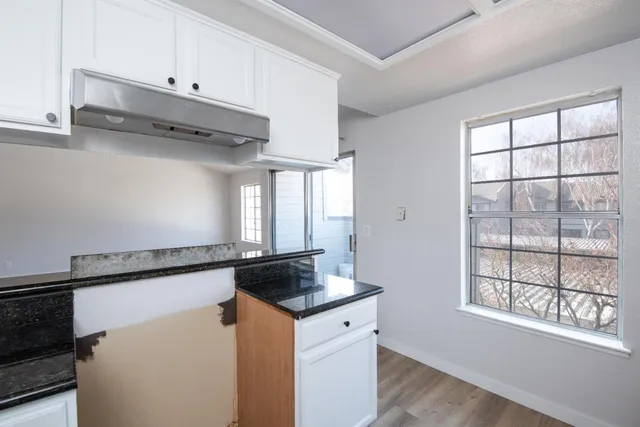 a kitchen with granite countertop a sink cabinets and a window