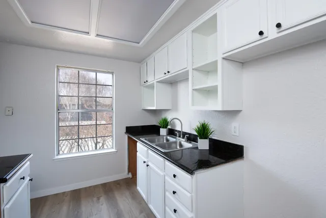 a kitchen with stainless steel appliances a sink a stove a window and cabinets