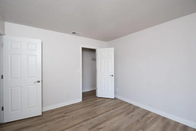 a view of an empty room with wooden floor