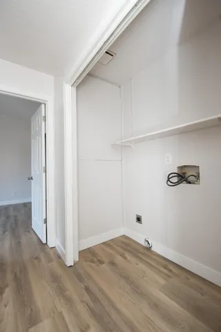 a view of empty room with wooden floor