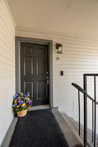 a view of a door and chair and potted plants