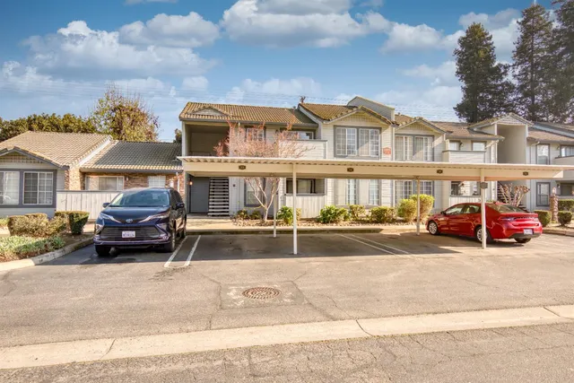 a front view of a house with cars parked