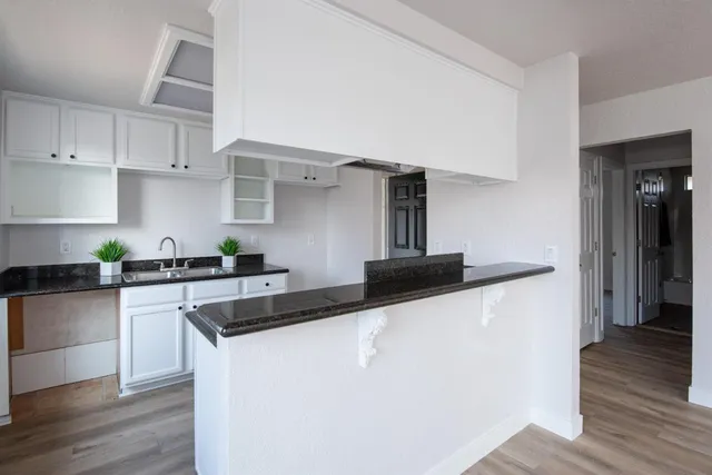 a kitchen with granite countertop a sink and a stove top oven