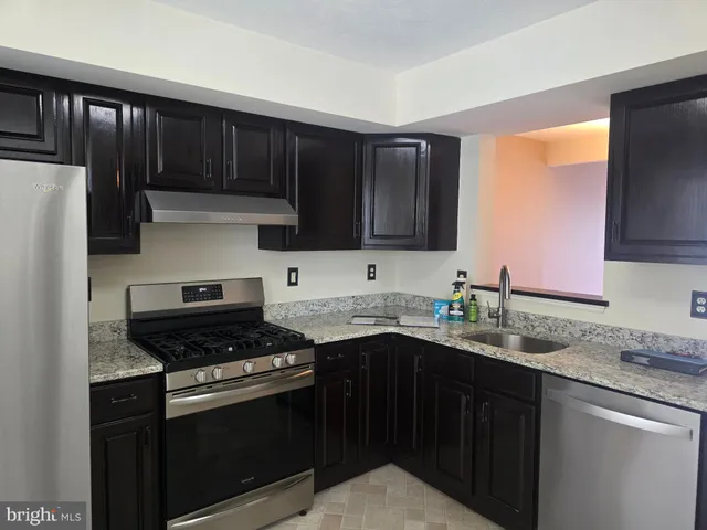 a kitchen with stainless steel appliances a sink dishwasher stove and refrigerator