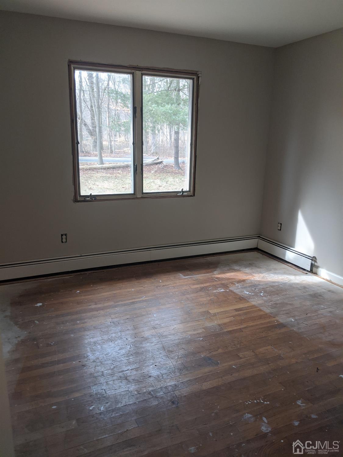 154 Broadway Road Cranbury, NJ 08512 - Photo 6 of 15 an empty room with wooden floor and windows