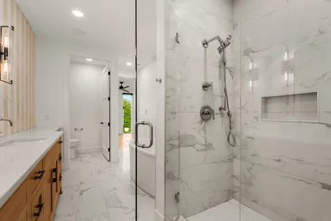 a bathroom with a granite countertop sink a toilet and shower