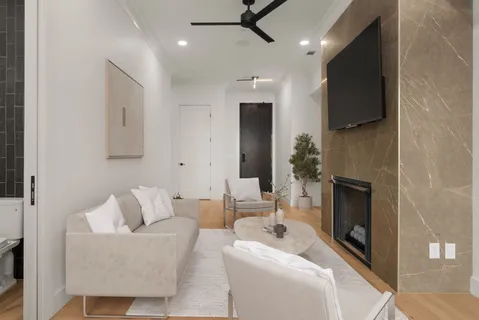 a living room with furniture a fireplace and a flat screen tv