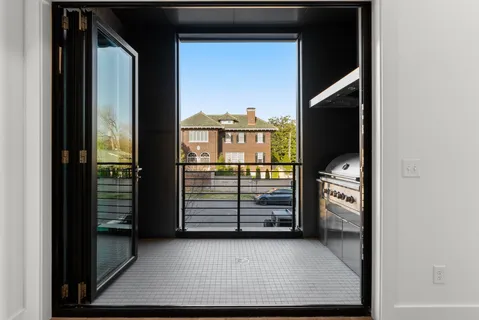 a view of a hallway with wooden floor and windows