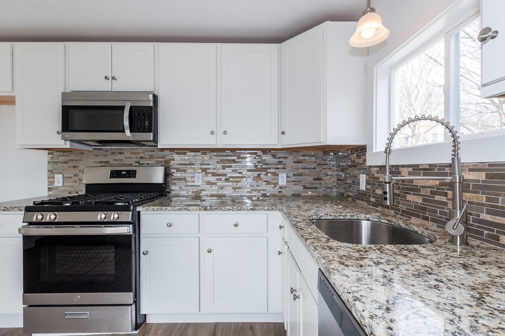 9 Camp Street Wareham, MA 02558 - Photo 11 of 30 a kitchen with granite countertop white cabinets stainless steel appliances and a window