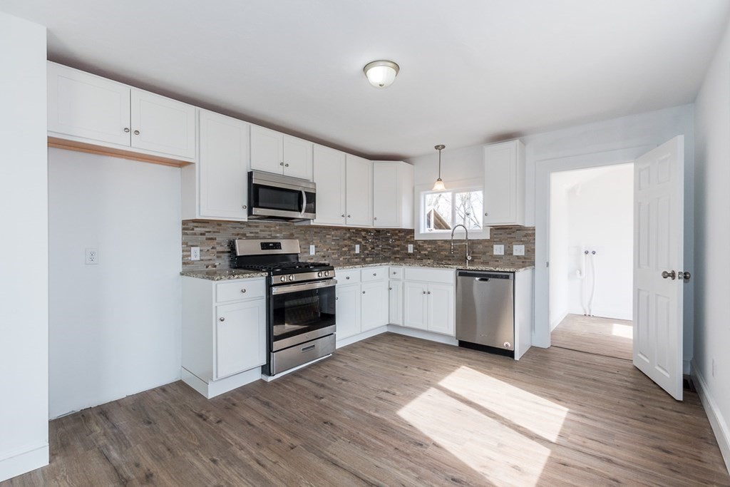 9 Camp Street Wareham, MA 02558 - Photo 9 of 30 a kitchen with granite countertop white cabinets and stainless steel appliances