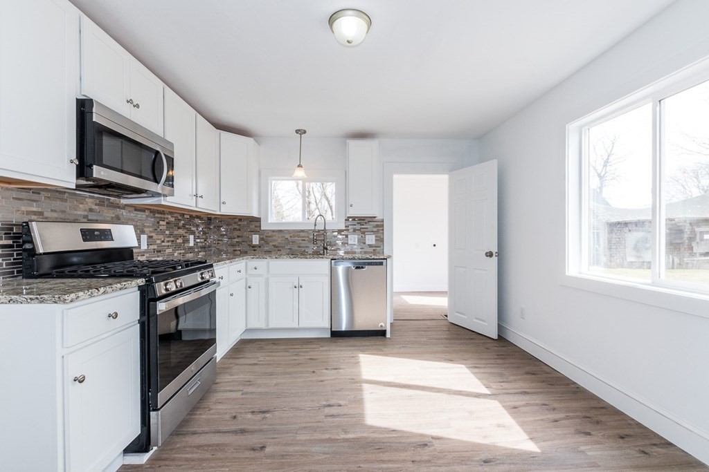 9 Camp Street Wareham, MA 02558 - Photo 10 of 30 a kitchen with stainless steel appliances granite countertop a stove a sink and a microwave
