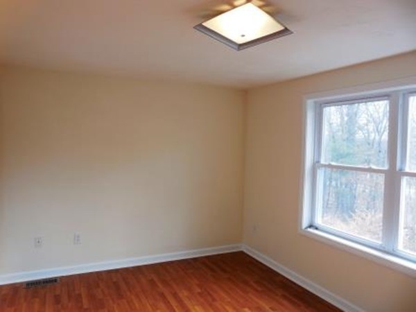5 Kingsbury Road Webster, MA 01570 - Photo 12 of 29 an empty room with wooden floor and windows