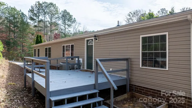 a view of house with a deck and furniture