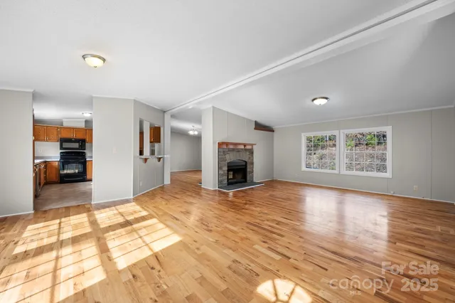 a view of empty room with wooden floor and fireplace