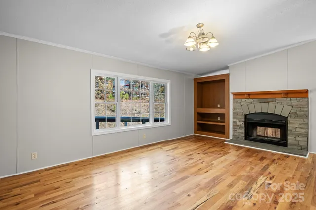 a view of an empty room with a fireplace and a window