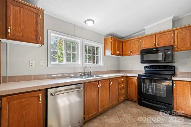 a kitchen with stainless steel appliances granite countertop a sink stove and microwave
