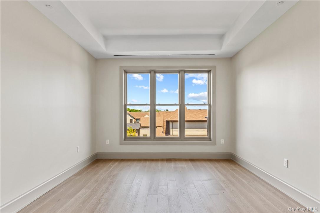 120 Old Post Road, Unit PHE303 Rye, NY 10580 - Photo 11 of 29 an empty room with wooden floor and windows