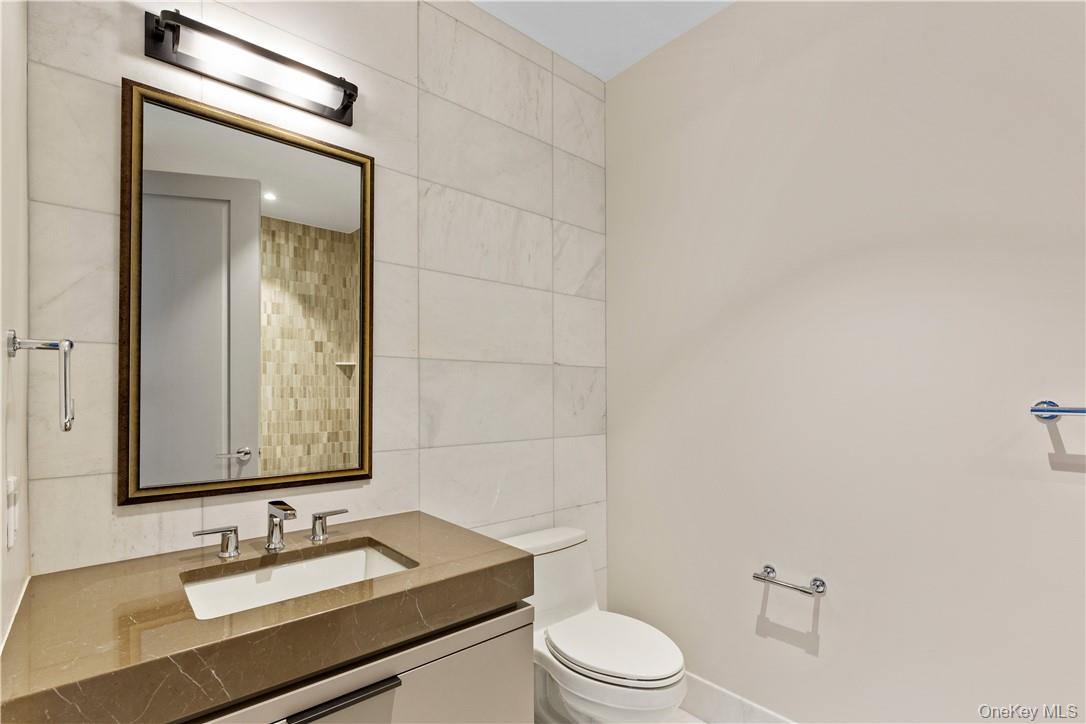 120 Old Post Road, Unit PHE303 Rye, NY 10580 - Photo 12 of 29 a bathroom with a granite countertop sink toilet a mirror and shower