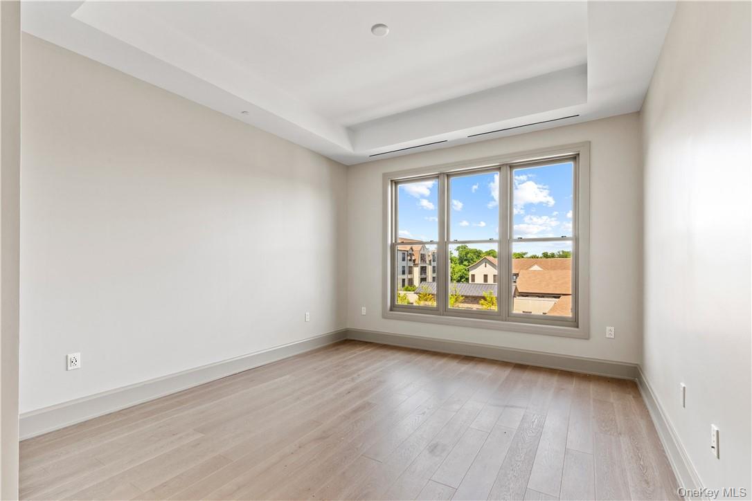 120 Old Post Road, Unit PHE303 Rye, NY 10580 - Photo 9 of 29 an empty room with wooden floor and windows