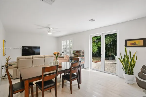 a living room with patio furniture and a potted plant