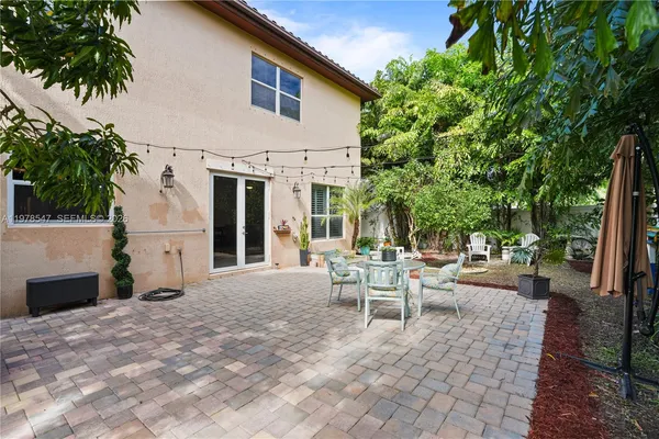 a view of a patio with table and chairs and potted plants