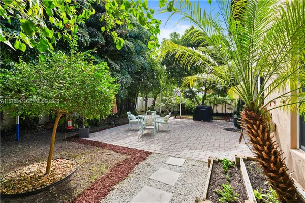 a front view of a house with a yard and potted plants