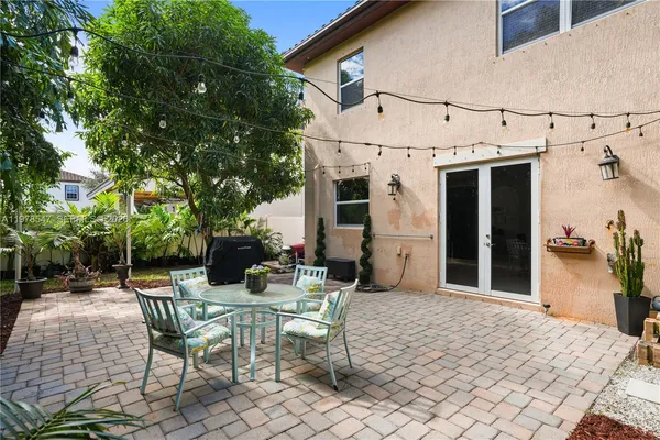 a front view of a house with a yard and potted plants