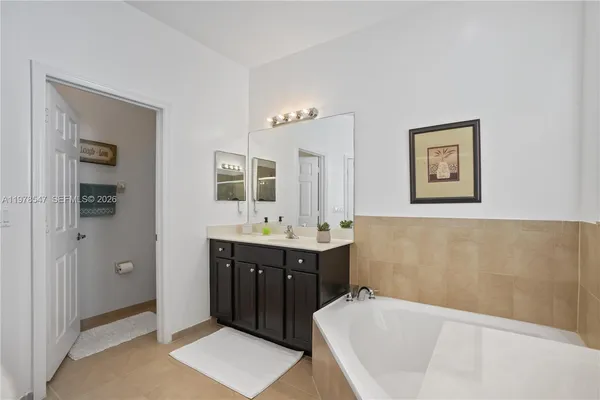 a bathroom with a tub a sink and mirror