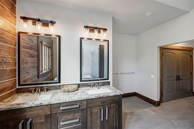 a bathroom with double sink and two mirror