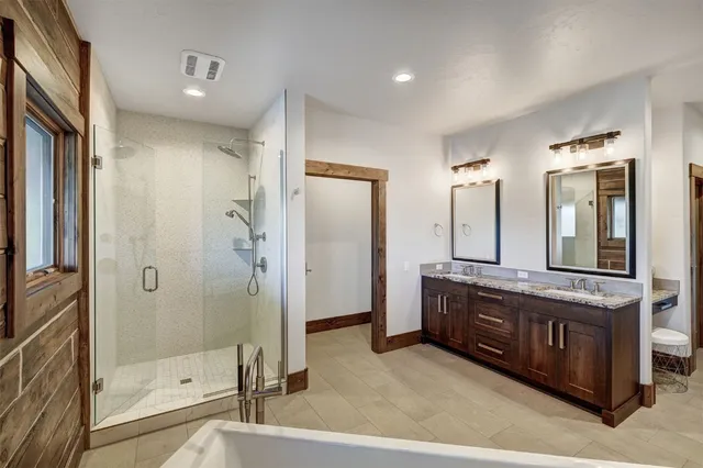 a spacious bathroom with a granite countertop sink mirror and shower