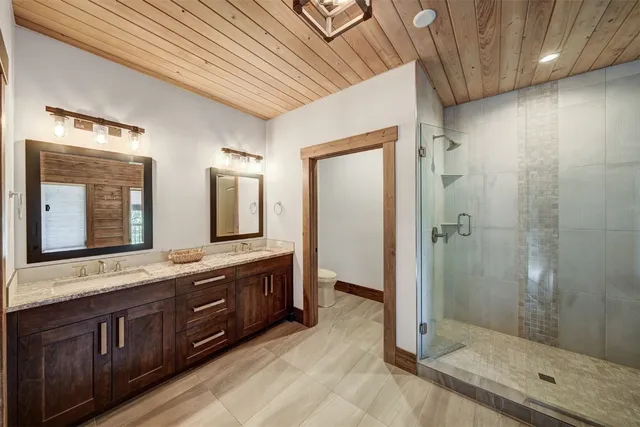 a spacious bathroom with a granite countertop sink mirror and shower