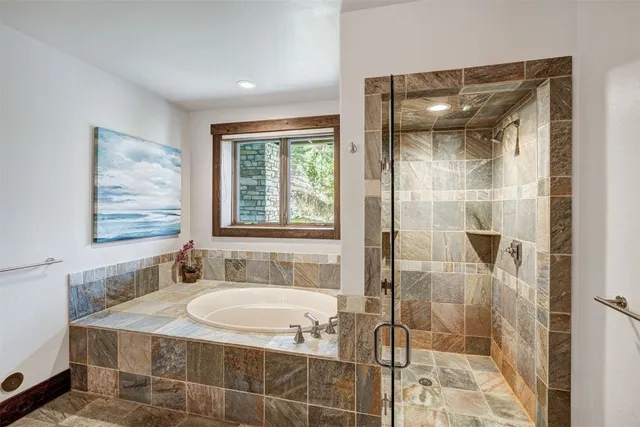 a bathroom with a granite countertop sink a mirror and shower
