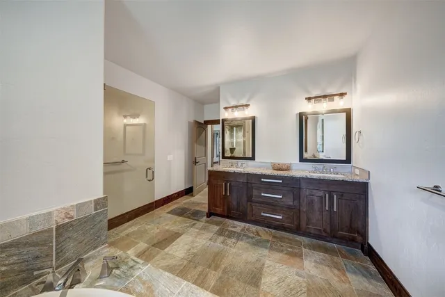 a spacious bathroom with double vanity and a mirror