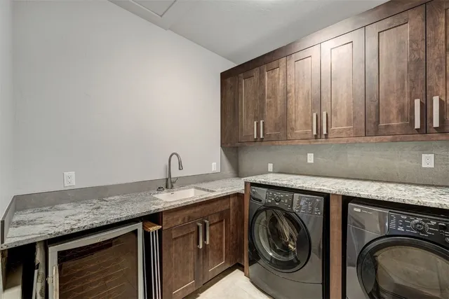 a utility room with granite countertop cabinets washer and dryer