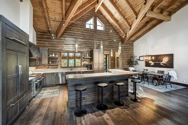 a kitchen with lots of wooden cabinets table and chairs
