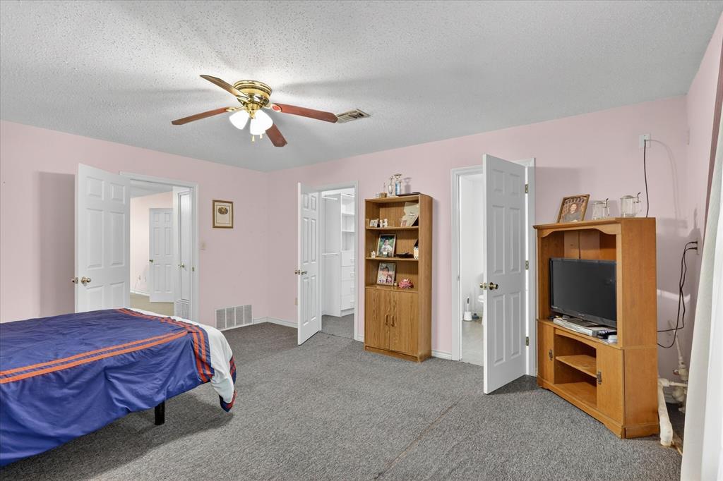 1092 West Highway 199 Springtown, TX 76082 - Photo 14 of 29 Spacious bedroom with walk in closet and ensuite bathroom