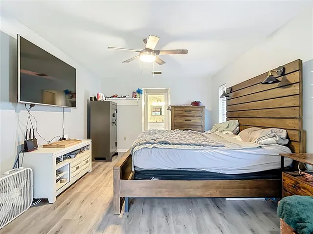 a bedroom with a bed and a flat tv screen on dresser