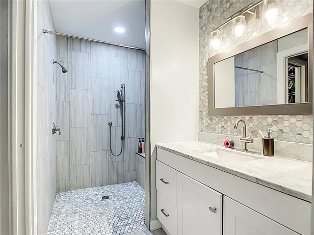 a bathroom with a shower sink and mirror