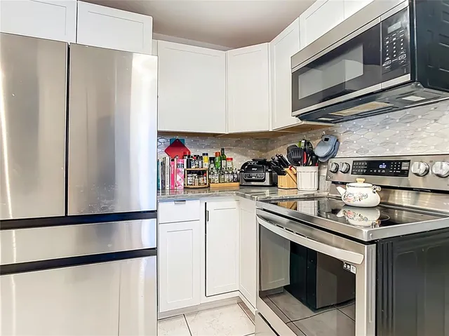 a kitchen with stainless steel appliances granite countertop a refrigerator stove and microwave