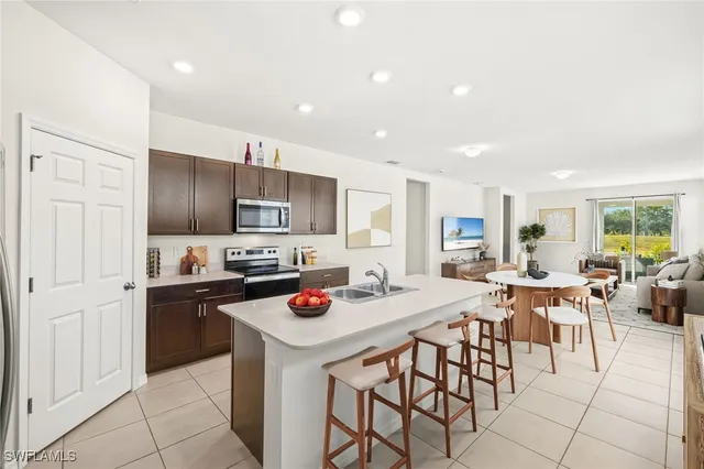 a kitchen with a sink a stove and chairs